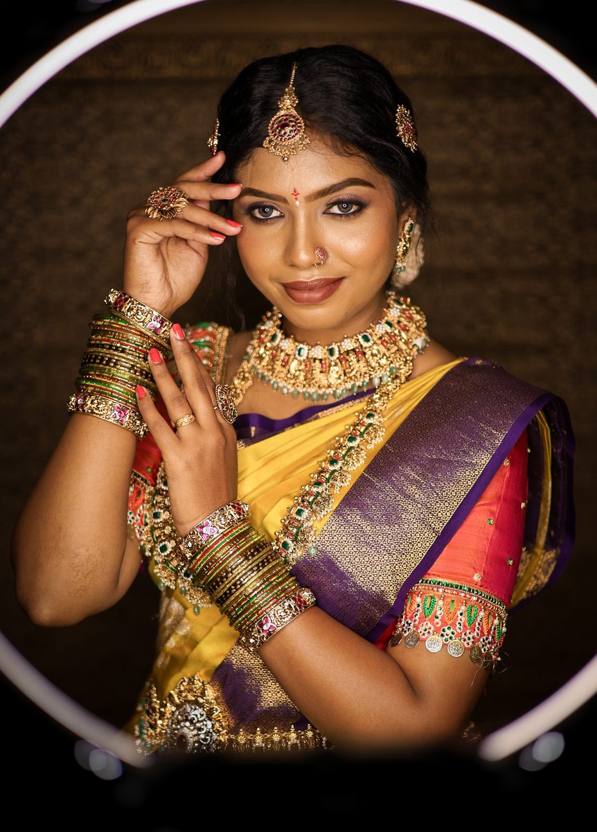 Bride in yellow Kanjivaram with gold choker, temple jewellery and green bangles