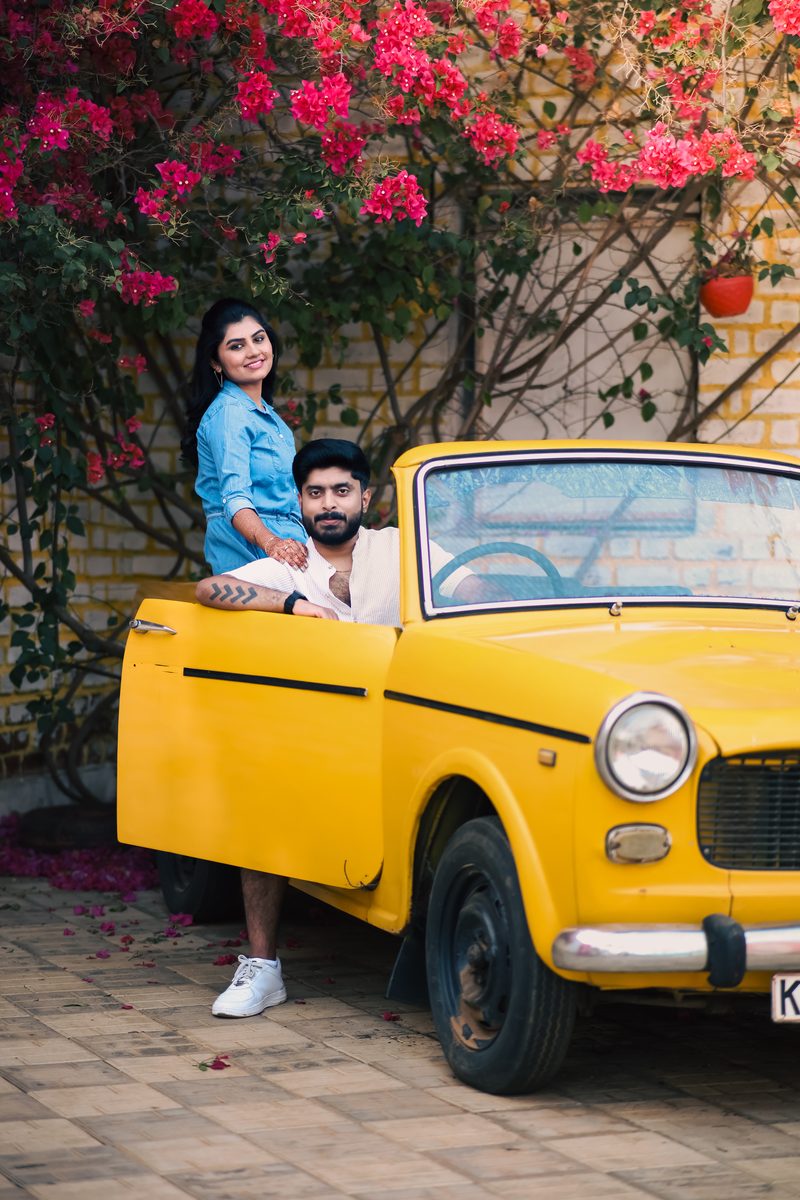 Couple posing with a yellow vintage Premier Padmini against a brick wall